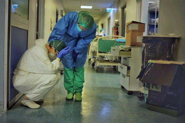 Intensive care professionals comfort each other in the ICU of a hospital in Cremona, Italy, on Friday, March 13, 2020 - Paolo Miranda